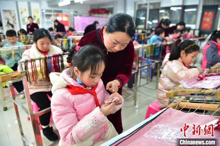 江西省級非遺豫章繡傳承人手把手指導小學生繡制2022年北京冬奧會吉祥物“冰墩墩”形象?！∮髟屏?攝
