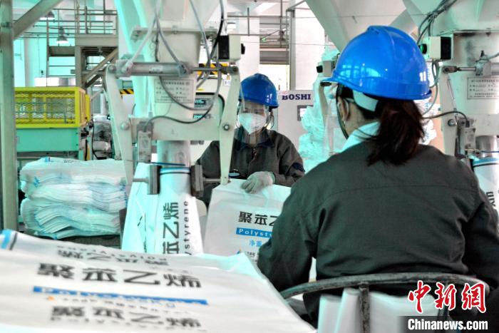 工人在生產(chǎn)線上包裝聚苯乙烯產(chǎn)品?！×趾霔v 攝