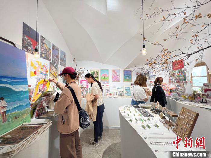 圖為藝術(shù)品商店內(nèi)，顧客挑選插畫(huà)作品。　鐘旖 攝