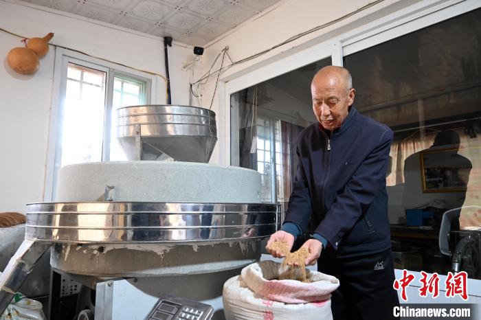 李家莊村民谷文朝重拾父輩的手藝，做起石磨面粉的營生?！〉杂鸺?攝