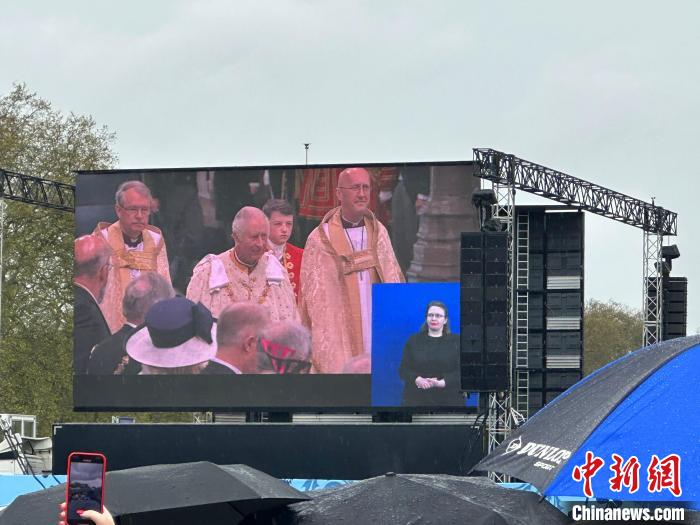 當(dāng)?shù)貢r(shí)間5月6日，英國國王查爾斯三世的加冕儀式舉行。民眾雨中觀看儀式。　歐陽開宇 攝