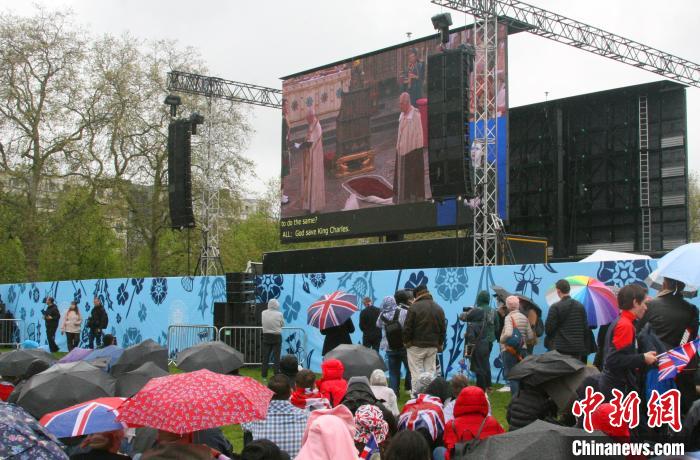 當(dāng)?shù)貢r(shí)間5月6日，英國國王查爾斯三世的加冕儀式舉行。民眾雨中觀看儀式。　歐陽開宇 攝