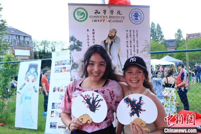 孩子們展示自己的吹墨畫團(tuán)扇作品?！◆斻肟鬃訉W(xué)院供圖