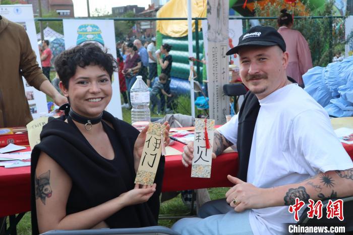 當(dāng)?shù)孛癖娫跐h字體驗(yàn)工作坊展示自己手寫的中文名書簽。　魯汶孔子學(xué)院供圖