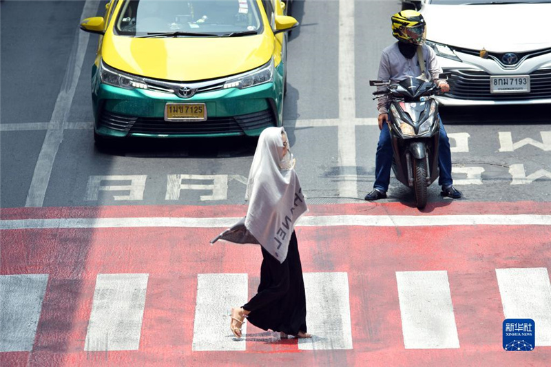 5月17日，行人在泰國曼谷街頭用圍巾遮陽。新華社發(fā)（拉亨攝）