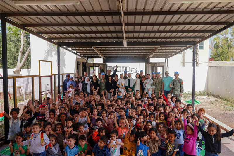 當(dāng)?shù)貢r(shí)間5月30日，黎巴嫩南部庫雷拉公立小學(xué)，“六一”國(guó)際兒童節(jié)前夕，中國(guó)第21批赴黎維和多功能工兵分隊(duì)官兵看望慰問學(xué)校師生，并開展文化交流活動(dòng)，圖為我維和官兵同師生合影。李竹林?jǐn)z