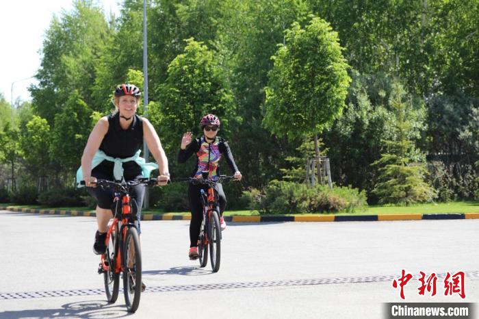 亞信副秘書長遲方(右一)與聯(lián)合國駐哈協(xié)調(diào)員在騎行活動中?！喰琶貢幑﹫D