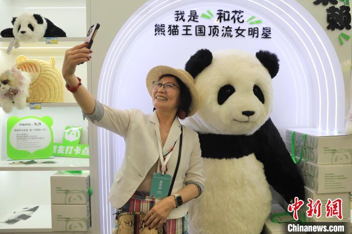 美國華視總裁楊蓮花與大熊貓文創(chuàng)產(chǎn)品合影?！⊥趵?攝