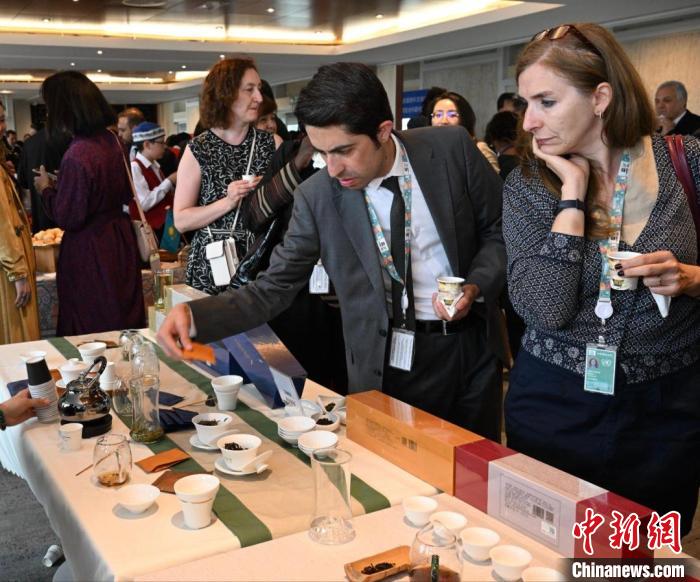 現(xiàn)場觀眾觀看中國展臺茶藝表演、了解茶文化。　靖樹 攝