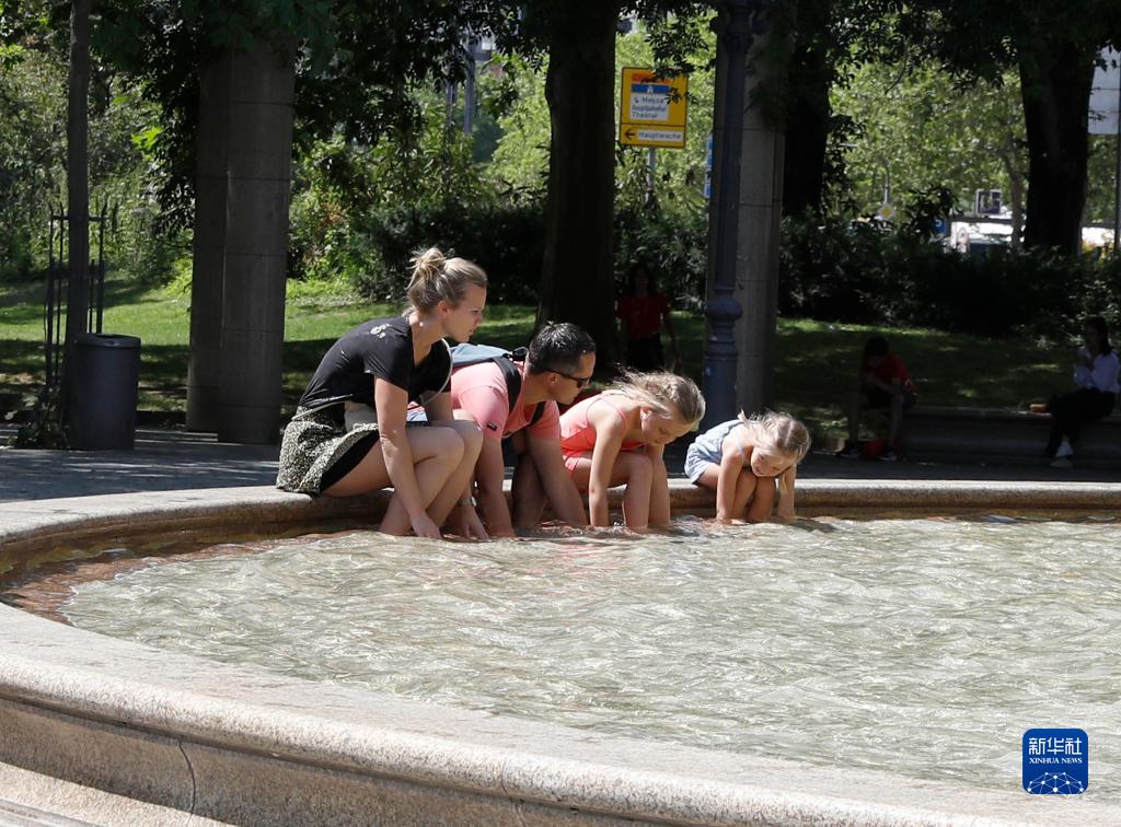 7月8日，人們在德國法蘭克福的一處噴泉玩水。近日，德國法蘭克福逐漸迎來暑熱天氣。新華社記者 張帆 攝