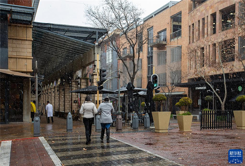 7月10日，在南非約翰內(nèi)斯堡一處商業(yè)區(qū)，人們在雪中行走。新華社記者 張譽(yù)東 攝