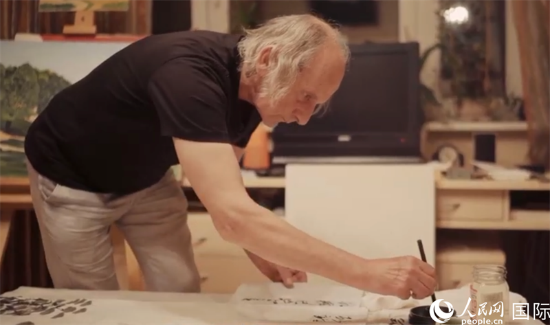 伊戈爾·布爾東諾夫在畫作上題詞。人民網(wǎng)記者 馬天翼攝