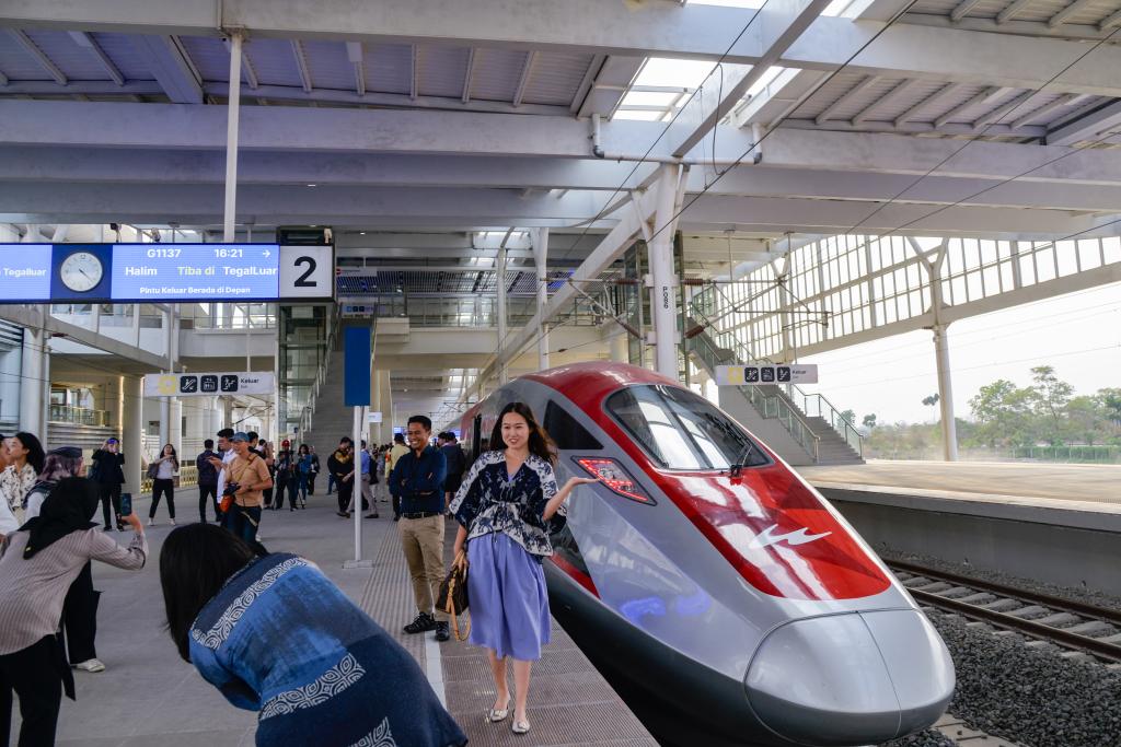 10月17日，在印度尼西亞萬隆德卡魯爾站，乘客在站臺上和雅萬高鐵高速動車組列車合影。