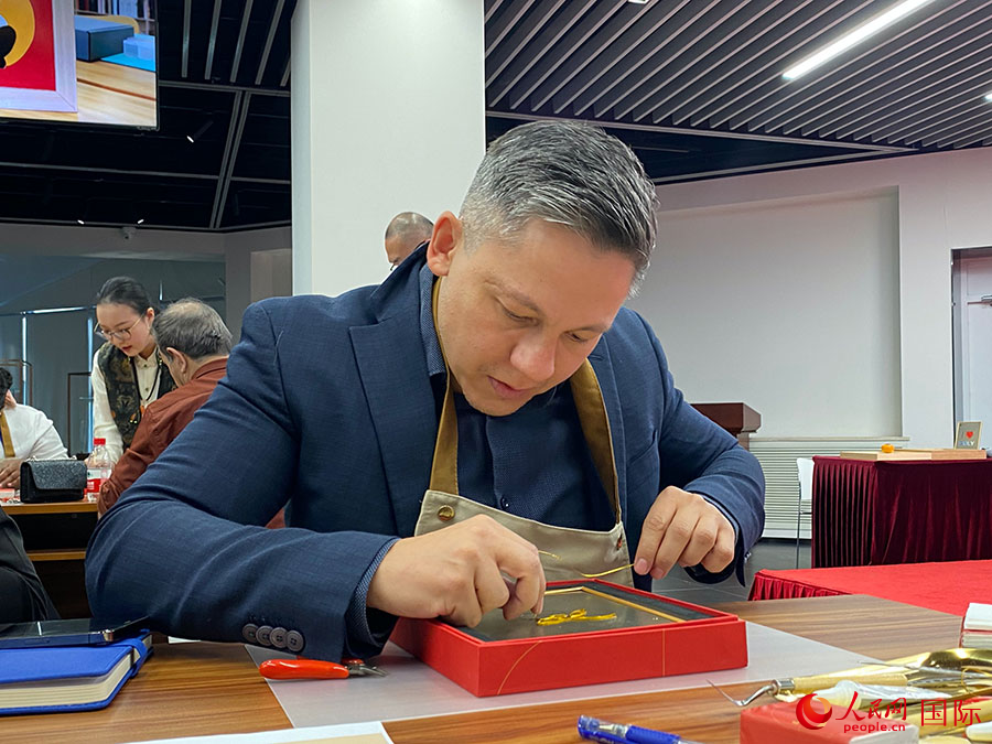 2023“一帶一路”媒體合作論壇聯(lián)合采訪團(tuán)團(tuán)員，親身體驗(yàn)景泰藍(lán)工藝。人民網(wǎng)記者 于洋攝