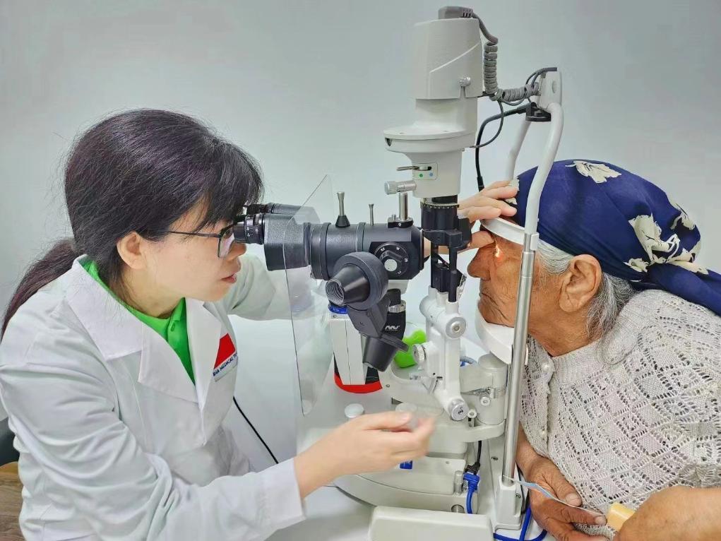 北京大學(xué)人民醫(yī)院眼科醫(yī)生鮑永珍正在為中亞白內(nèi)障患者進(jìn)行眼部檢查。（北京大學(xué)人民醫(yī)院供圖）