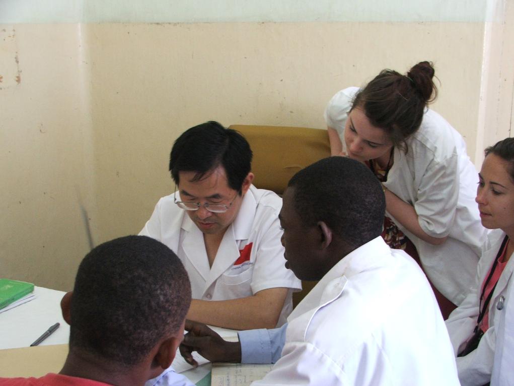 2011年7月22日，在坦桑尼亞桑給巴爾納茲莫加醫(yī)院外科門診，中國(guó)第24批援桑給巴爾醫(yī)療隊(duì)隊(duì)長(zhǎng)盧建林為當(dāng)?shù)鼗颊咴\治并帶教實(shí)習(xí)生。新華社發(fā)（國(guó)家衛(wèi)生健康委供圖）