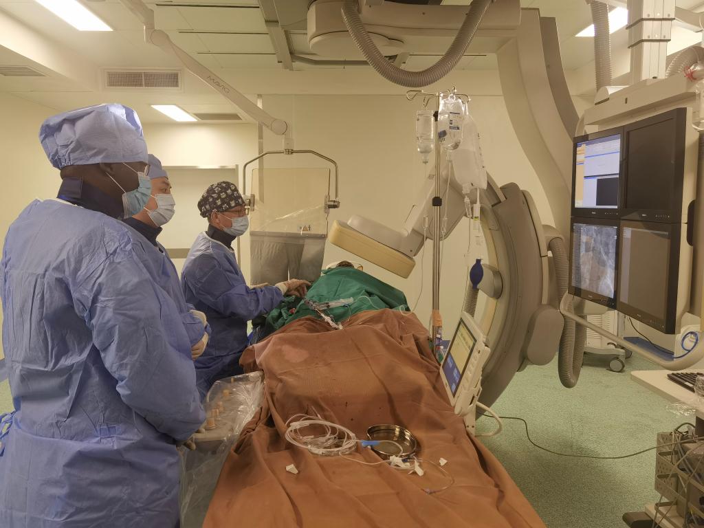 中國(guó)第29批援幾內(nèi)亞醫(yī)療隊(duì)隊(duì)員、首都醫(yī)科大學(xué)附屬北京天壇醫(yī)院心內(nèi)科副主任醫(yī)師王汝朋（右一）正在給患者做手術(shù)。（北京天壇醫(yī)院供圖）