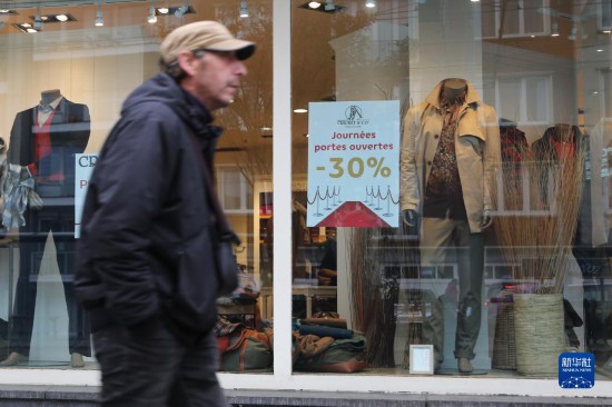   10月31日，一名男子從比利時(shí)布魯塞爾一家貼有打折信息的店鋪前走過(guò)。新華社記者 趙丁喆 攝