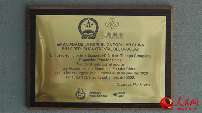 小學(xué)墻上懸掛的中國(guó)援助標(biāo)識(shí)。人民網(wǎng)記者 張若涵攝