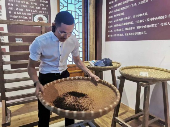 2023“一帶一路”媒體合作論壇聯(lián)合采訪團(tuán)團(tuán)員在非遺文化展示館體驗中藥炮制技藝。（本報記者 黃超攝）