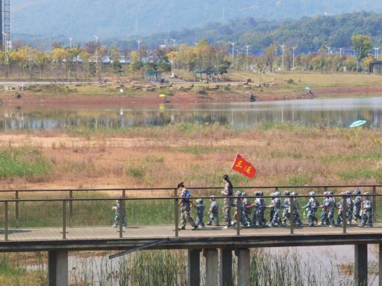 　　10月24日，秋游的幼兒園小朋友在老師帶領(lǐng)下走在清水塘公園里的木橋上。本報(bào)記者 常雯宜攝