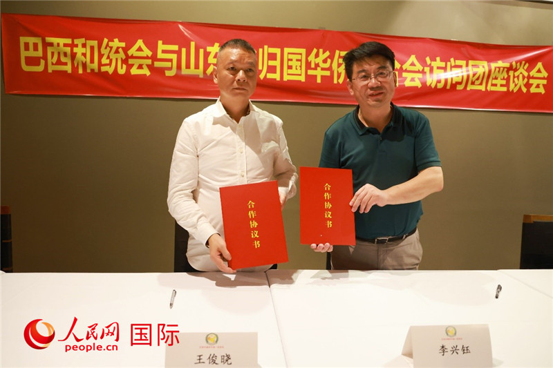 中國僑聯(lián)副主席、山東省僑聯(lián)主席李興鈺（右）與巴西和統(tǒng)會會長王俊曉簽署合作協(xié)議書。人民網(wǎng)記者 陳海琪攝