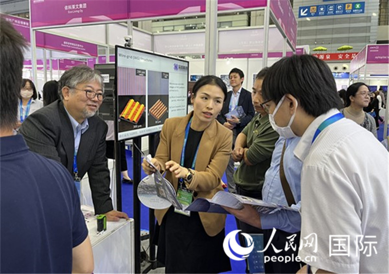 工作人員向參觀者介紹超級噴墨技術(shù)。（人民網(wǎng)記者 陳思攝）