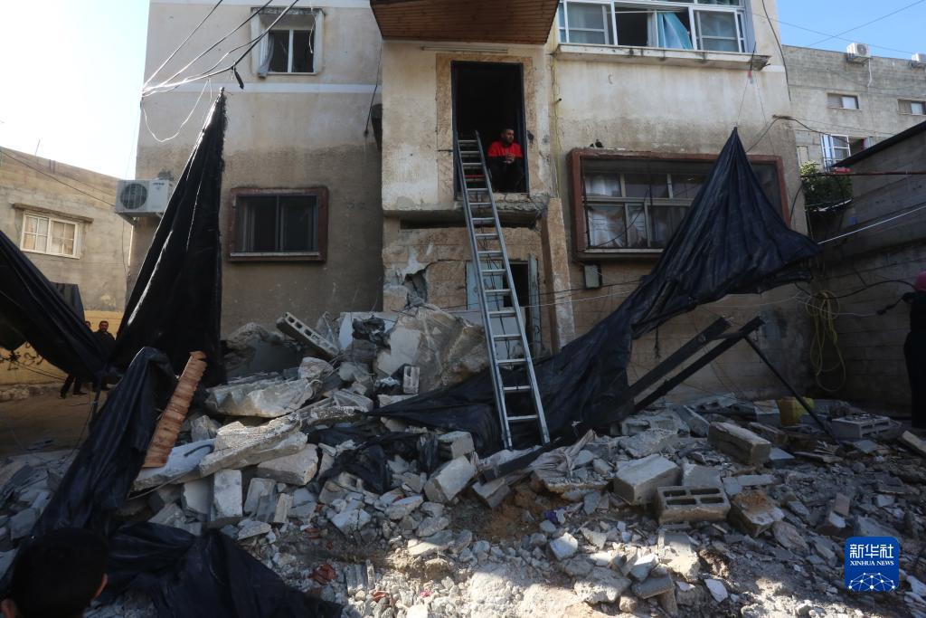 12月17日，在約旦河西岸城市圖勒凱爾姆附近的一處難民營，人們查看在沖突中損毀的房屋。新華社發(fā)（尼達爾·艾仕塔耶攝）