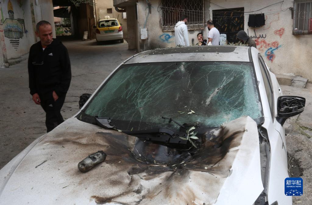 12月17日，在約旦河西岸城市圖勒凱爾姆附近的一處難民營，人們查看在沖突中損毀的車輛。新華社發(fā)（尼達爾·艾仕塔耶攝）