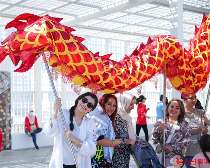 游客體驗(yàn)舞龍。 人民網(wǎng) 塔里克·易卜拉欣攝