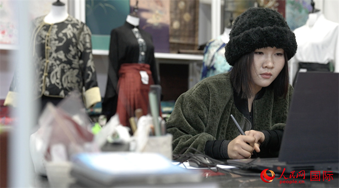 1月23日，在山東省菏澤市曹縣有愛云倉直播基地，張子晨正在設(shè)計漢服。 人民網(wǎng)記者 袁蒙攝