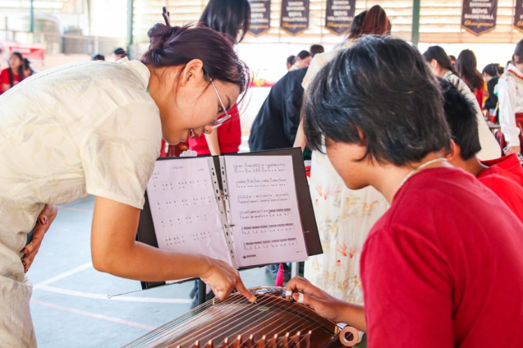 志愿者教師指導(dǎo)學(xué)生彈奏古箏?；顒?dòng)主辦方供圖