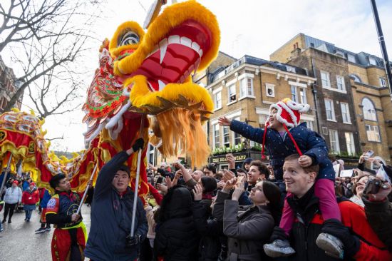 2月11日，人們在英國倫敦的新春巡游活動中觀看舞龍表演。新華社發(fā)（史蒂芬·程攝）