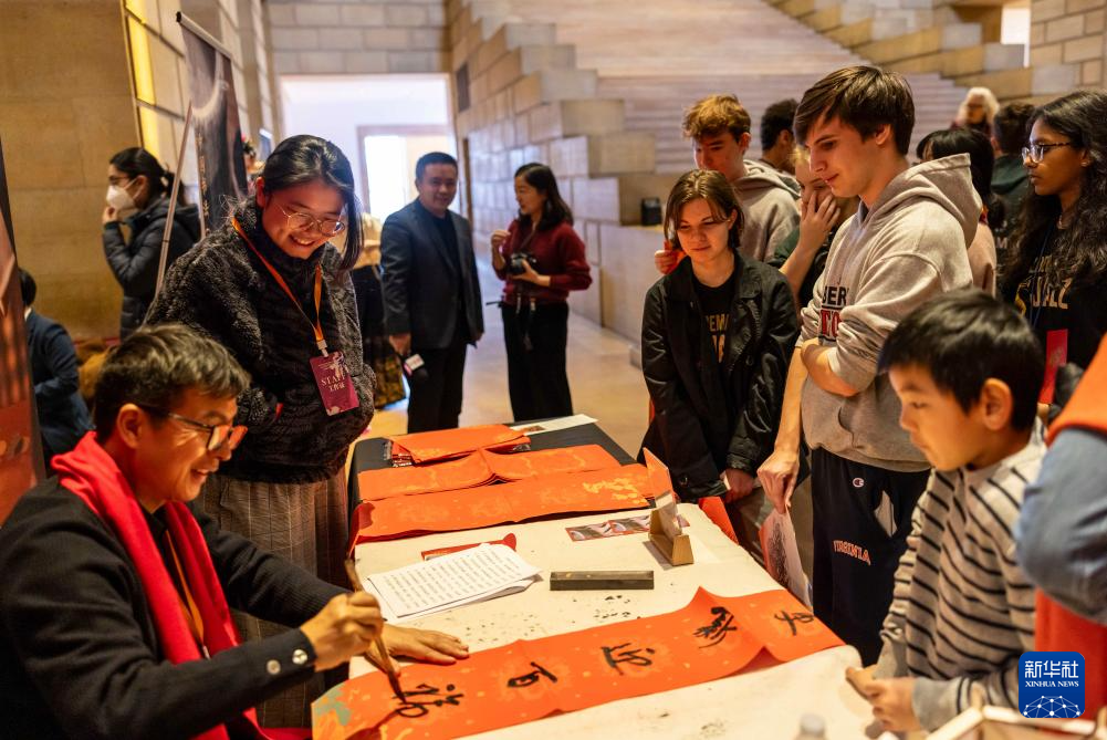 2月11日，書(shū)法家在美國(guó)費(fèi)城藝術(shù)博物館舉行的龍年迎新春活動(dòng)上為參觀者書(shū)寫(xiě)對(duì)聯(lián)。新華社發(fā)（周煥新攝）