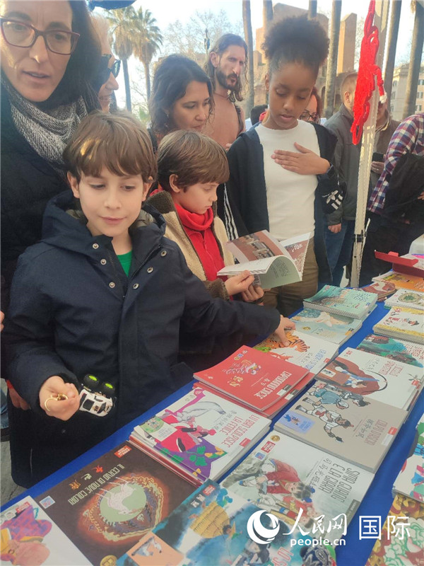 印刷精美的中國傳統(tǒng)文化叢書吸引了小游客的注意。人民網(wǎng)記者鄭彬攝