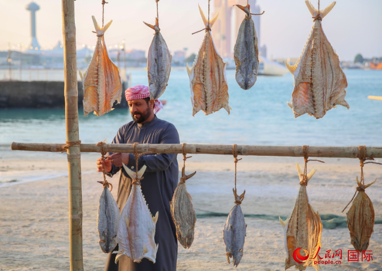    手工藝者展示如何晾曬魚干。人民網(wǎng) 塔里克·易卜拉欣攝