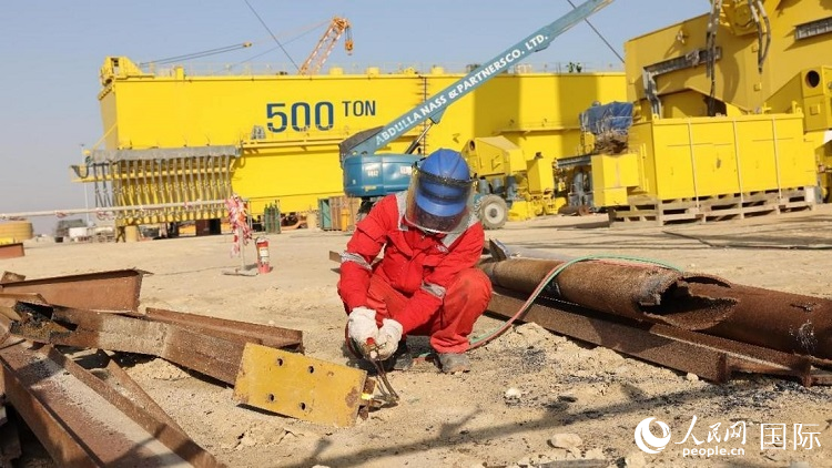 工人正在龍門(mén)吊吊裝現(xiàn)場(chǎng)切割金屬件。人民網(wǎng)記者管克江攝