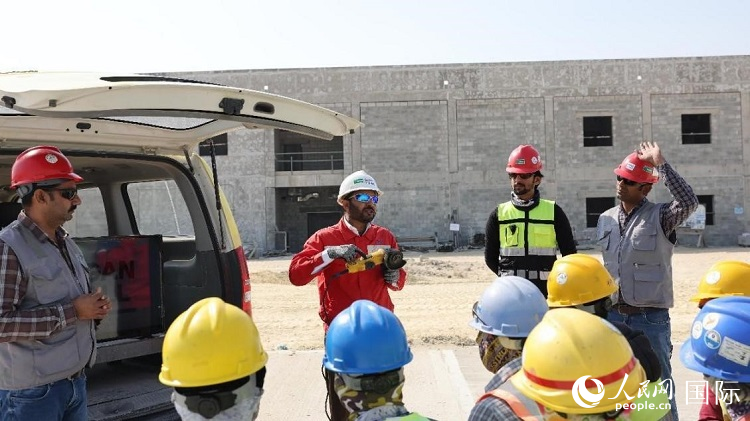 穆薩瓦爾(圖中紅衣人）現(xiàn)場(chǎng)演示工具操作規(guī)范。人民網(wǎng)記者 管克江攝