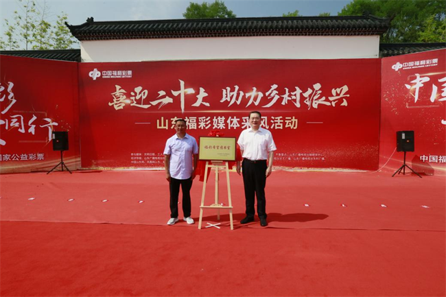 省福彩中心主任王偉與沂源縣徐家莊中心學校校長傅懷佳共同為“福彩希望圖書室”揭牌。 山東省福彩供圖）