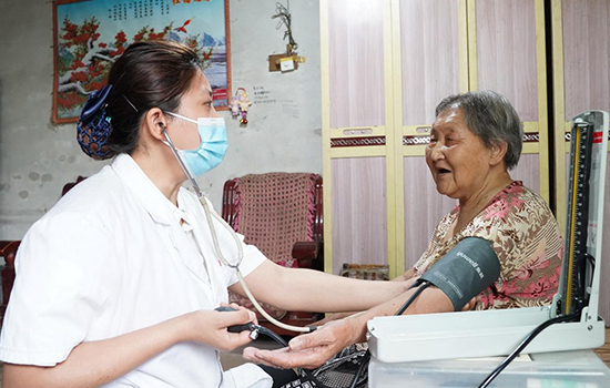 護(hù)理團(tuán)隊(duì)醫(yī)生為老人測量血壓。 陳佳兵攝