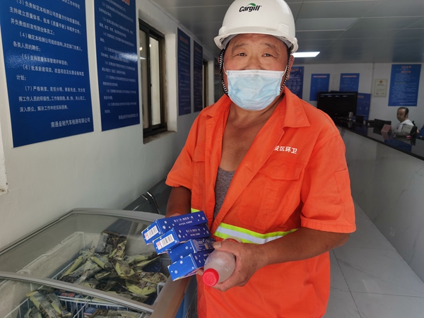 1環(huán)衛(wèi)工倪建宏小憩后，為還同事帶去冷飲。人民網記者王繼亮攝