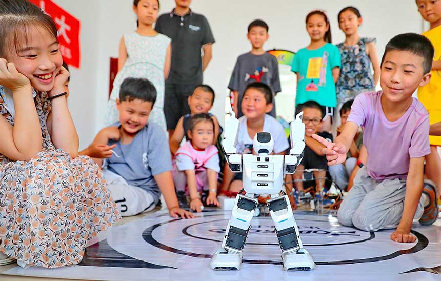 2022年7月19日，河北省秦皇島市海港區(qū)白塔嶺街道秦皇半島第二社區(qū)內(nèi)，小朋友正在觀看“機(jī)器人跳舞”。 曹建雄攝