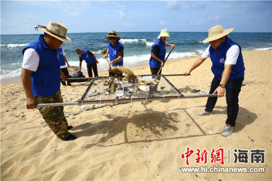 環(huán)保志愿者用篩網(wǎng)“淘”出海灘上的垃圾。