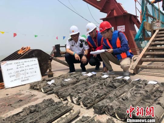 圖為勘察設(shè)計(jì)人員與海事局工作人員查看巖芯情況?！∥赫?攝