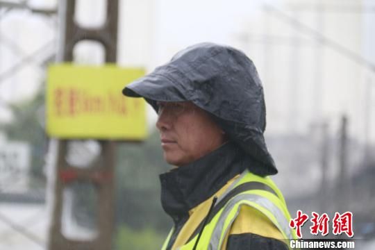蘭州西工務(wù)段蘭州線路車間防護(hù)員雨中巡查?！⊥豕廨x 攝
