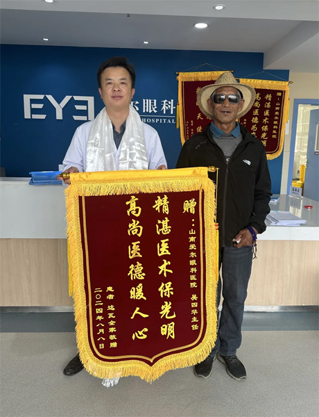 達瓦老人向吳四華（左）贈送錦旗。受訪者供圖