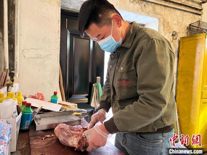 圖為雪豹“奶爸”史壽軍正在準(zhǔn)備投喂雪豹的食材?！●R銘言 攝