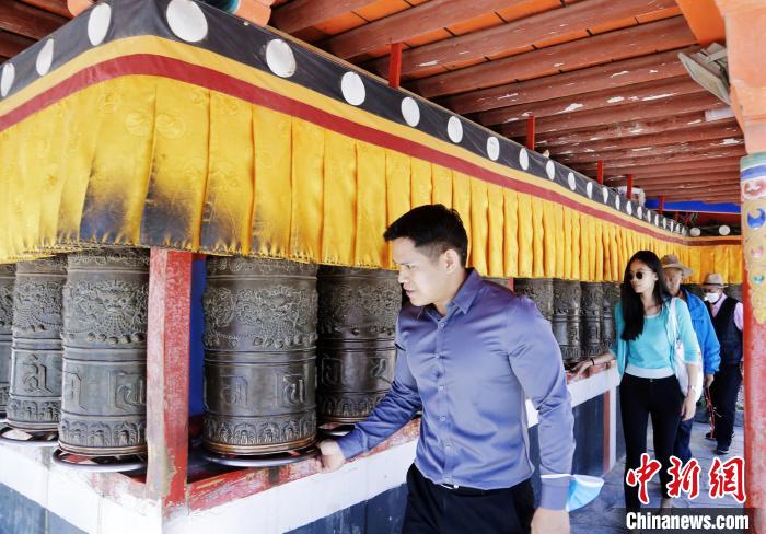 圖為外籍嘉賓體驗藏族傳統(tǒng)轉(zhuǎn)經(jīng)筒?！●R銘言 攝