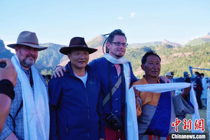 圖為當(dāng)?shù)孛癖娕c外籍?dāng)z影師合影留念?！●R銘言 攝