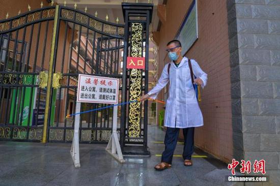 資料圖：?？诮?jīng)濟(jì)學(xué)院的工作人員在學(xué)生宿舍樓入口消毒。 中新社記者 駱云飛 攝